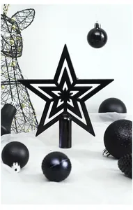 Detalle de una estrella negra calada para árbol de Navidad con adornos a juego