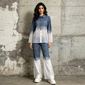 Vue complète d'un ensemble deux pièces en denim dégradé sur fond de mur en béton.
