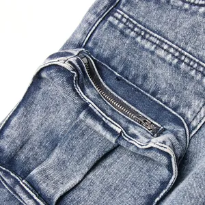 Macro view of cargo pocket with metal zipper on vintage acid-wash blue denim skirt