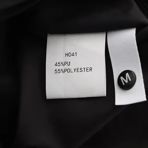Detail of the material tag for a black PU leather skirt showing composition and size.