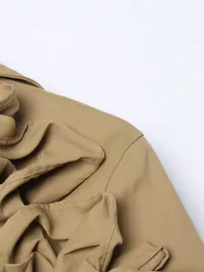 Close-up detail of khaki trench coat showing elegant ruffle stitching and fabric texture