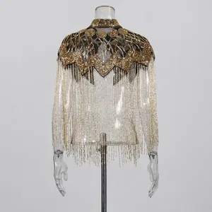 Detailopname van gouden kralenwerk en fonkelende lange franjes op deze Franse stijl cape.