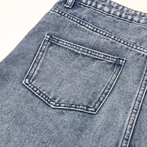 Close-up detail of high-waist denim skirt with acid wash texture and pocket stitching.