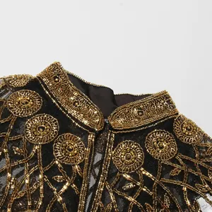 Detail van luxe gouden kralenborduurwerk op een zwarte mesh cape sjaal voor dames.