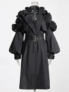 Elegant black mid-length trench coat featuring unique ruffle sleeve detailing and a waist belt