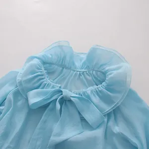 Close-up of light blue mesh blouse featuring elegant ruffled collar and bow tie detail