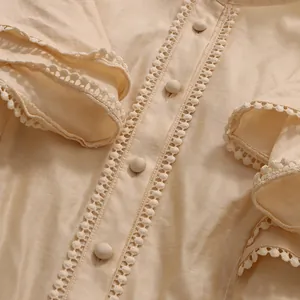 Close-up of vintage beige blouse with fly sleeves, fabric buttons and crochet lace trim