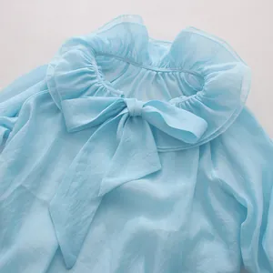 Detailed view of light blue mesh blouse featuring a sweet ruffled collar and bow tie detail