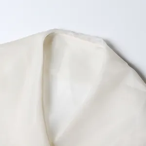 Detailed close-up view of a white sheer chiffon blouse neckline with elegant sewing