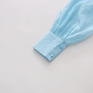 Detail of a light blue long-sleeved shirt cuff with elegant pleating and dual buttons