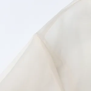 Close-up of the delicate sheer organza fabric and seam on a white palace-style shirt
