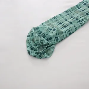 Detail der grün karierten Chiffon-Ärmel mit elastischem Bund für Damenblusen