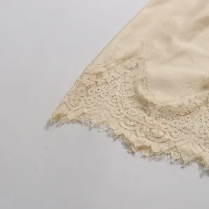 Close-up detail of exquisite vintage cream lace embroidery on elegant satin skirt hem