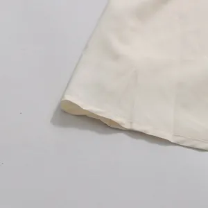 Detail view showing neat hemline stitching on elegant cream fabric for skirt set