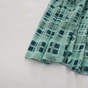 Detailaufnahme des Saums der grünen karierten Chiffonbluse mit hochwertigen Nähten