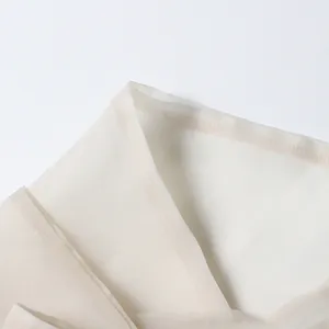 Detailed close-up showing the lightweight fabric and fine stitching on a beige vintage blouse