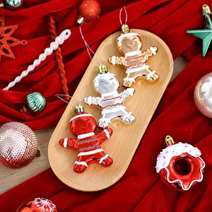 Set de adornos navideños de hombre de jengibre y rosquilla sobre terciopelo rojo.