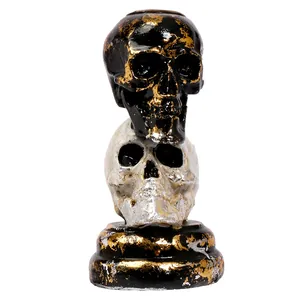 Gothic style black and white stacked skull resin ornament featuring gold and silver foil