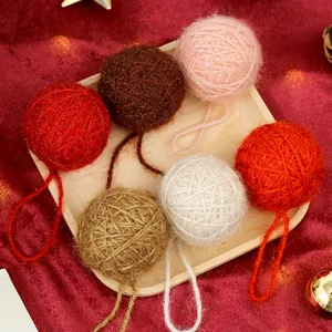 Set of cozy knitted yarn Christmas ball ornaments in assorted colors on a wooden tray