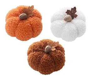 Detailed view of three plush pumpkins in orange, white, and brown with soft sherpa texture