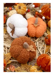 Close-up of assorted plush pumpkins in bouclé and velvet fabrics for autumn home decor
