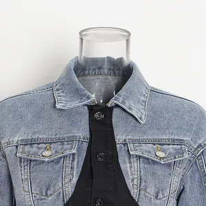 Nahaufnahme einer Damen-Jeansjacke mit schwarzem Kontrast-Patchwork und Kragendetails.