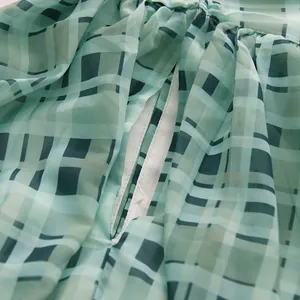 Nahaufnahme von grünem kariertem Chiffonstoff mit einer sehr feinen Verarbeitungsqualität