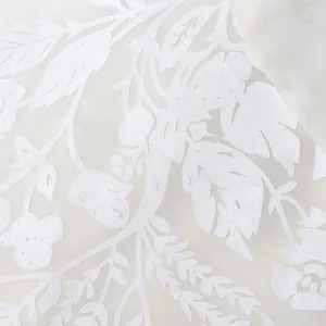 Macro view of white floral jacquard pattern on elegant retro palace style blouse fabric