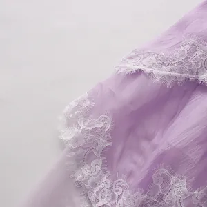 Macro view of delicate white lace trim and lavender crinkled fabric on French dress.