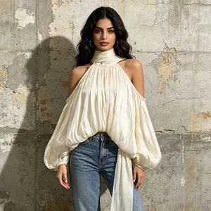Détail du haut dos nu crème de style français avec texture plissée et manches bouffantes.