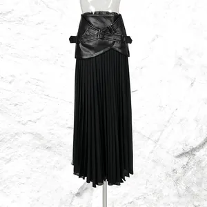 Gros plan sur une jupe longue plissée noire avec taille en similicuir et maille fine