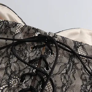 Detailaufnahme eines schwarzen Spitzenkorsetts mit Schnürung und Pailletten