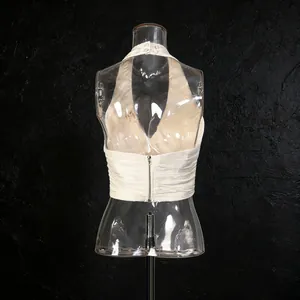 Detail view of a French-style halter-neck sleeveless top with back zipper and pleated texture.