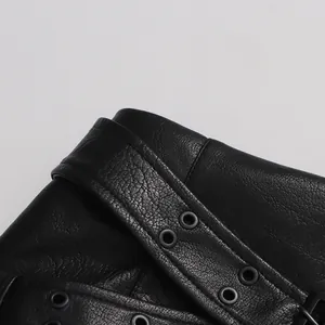 Détail de la taille d'une jupe en similicuir noir avec ceinture et œillets métalliques