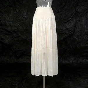 Detailed view of an elegant cream-colored pleated maxi skirt in French style design