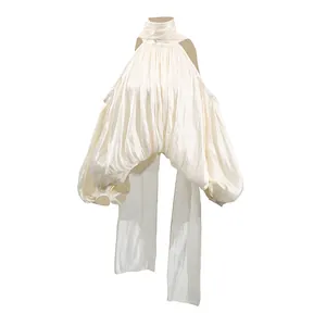 Détail d'un chemisier en satin blanc à dos nu et manches bouffantes élégantes