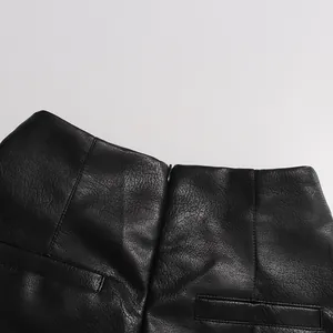 Gros plan de la taille d'une jupe en similicuir noir avec texture à grain fin et zip