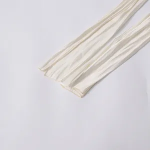 Gros plan sur la texture plissée d'un ruban de chemisier crème de style français élégant