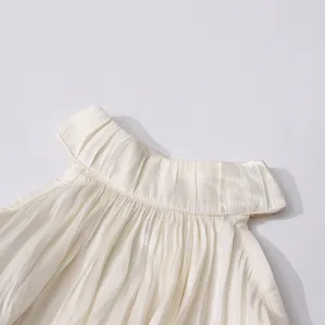 Détail macro du col montant plissé d'une blouse en mousseline blanche de style français.