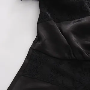 Dettaglio macro che mostra pizzo floreale nero e patchwork di raso su top stile vintage