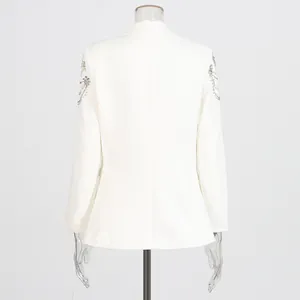 Detailed back view of white blazer featuring intricate shoulder beadwork and rhinestones.
