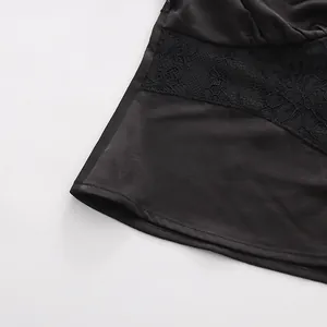 Vista ravvicinata di un top in raso nero stile vintage con delicati inserti in pizzo