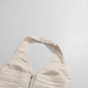 Close-up of French style ivory pleated halter top with neck button detail