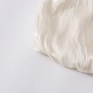 Vue détaillée du tissu en mousseline plissée blanche avec une texture soyeuse
