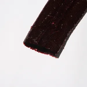 Macro shot showing high-density burgundy sequin texture on an elegant blazer sleeve detail.