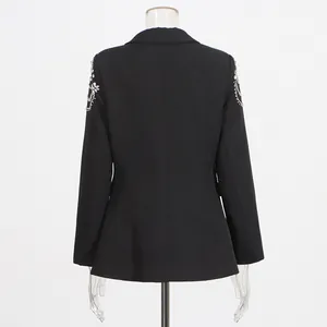 Detailed back view of a black blazer featuring heavy rhinestone shoulder beadwork.