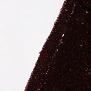 Close-up macro view of shimmering dark red sequins on a stylish women's blazer jacket