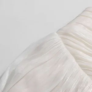 Detail macro shot of white pleated fabric with subtle shimmer texture for French style set.