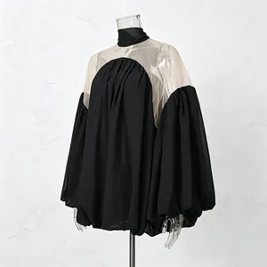 Vista detallada de elegante blusa negra de estilo francés con paneles de malla y mangas