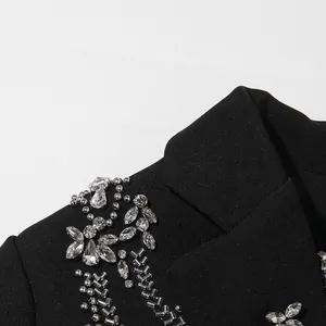 Detailed close-up of exquisite silver rhinestone and beadwork embellishment on a black blazer lapel